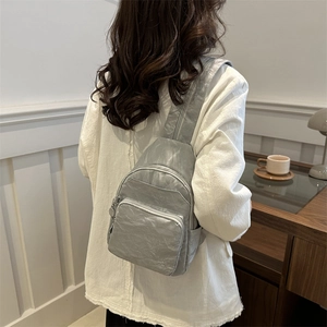Silver-grey casual crossbody chest bag with metallic texture shown on a female model
