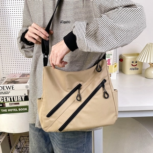 Minimalist large khaki tote bag with front diagonal zippers and adjustable shoulder strap