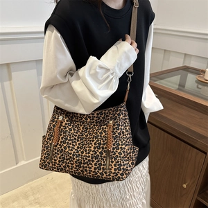 Leopard print tote bag with dual metal zippers and adjustable brown shoulder strap