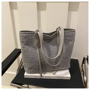 Detail view of the soft grey lamb wool texture and faux leather trim on a large tote bag