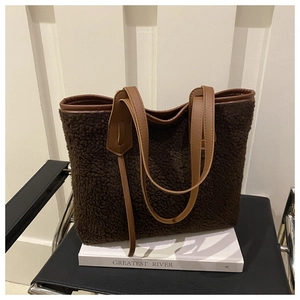 Detail of plush lamb wool tote bag with premium leather handles and brown teddy fabric
