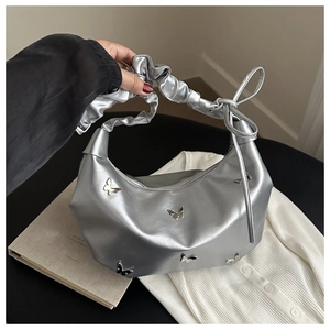 Détail du sac croissant argenté avec papillons 3D métalliques et poignée à plis doux