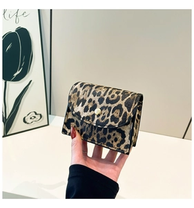 Close-up of leopard print mini bag featuring a gold snap button and textured faux leather