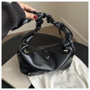 Détail du sac cabas noir avec poignées plissées et ornements de papillons en métal argenté