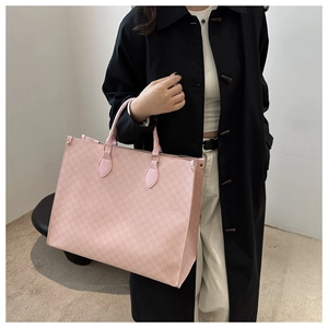 Détail du sac cabas en jacquard rose avec motif M et poignées en cuir