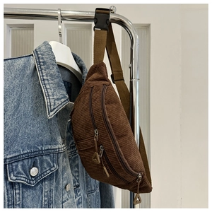 Detail of brown corduroy fanny pack with zippers and durable plastic buckle strap