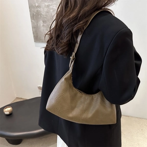 Minimalist brown suede hobo bag with adjustable strap shown on model in black blazer