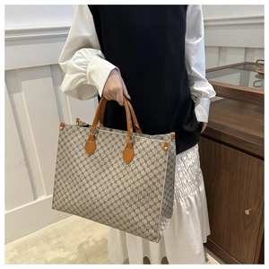 Détail du cabas vintage à monogramme avec poignées en cuir et boutons-pression latéraux