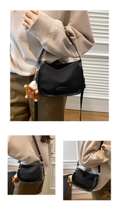 Detail of black crescent crossbody bag with waterproof nylon and plush animal charm