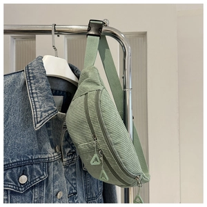 Detail of light green corduroy fanny pack with multi-layer zippers and adjustable strap