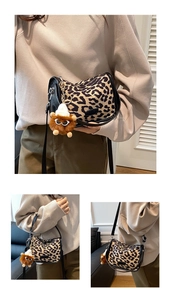 Macro detail of leopard print crescent bag with leather trim and plush charm