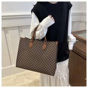 Détail du grand sac cabas avec motif monogramme marron et poignée en cuir élégante