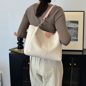 Large cream and pink tote bag with chain strap shown on model for daily commute