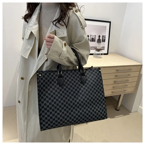 Détail du grand sac cabas monogramme vintage avec anses en cuir et finitions dorées