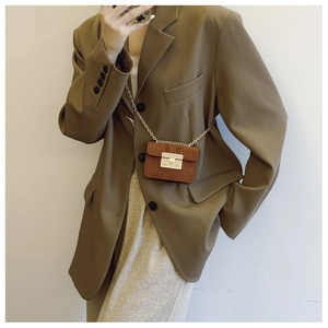 Detail showing the brown suede micro crossbody bag with gold metal buckle and chain strap