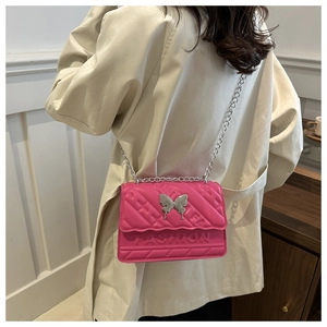 Detail of rose pink quilted crossbody bag with silver butterfly clasp and chain strap