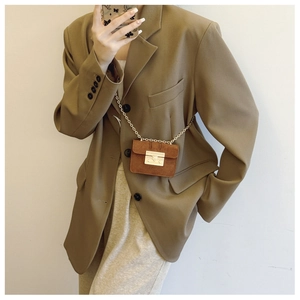 Detailed view of brown mini crossbody bag with gold chain and metal clasp closure