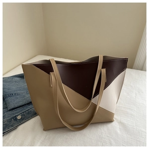 Close-up of a large tote bag with brown, khaki, and cream geometric color-block design