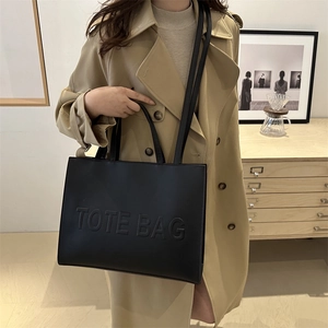 Minimalist black leather tote bag with embossed lettering and dual shoulder straps
