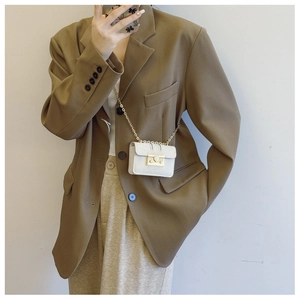 Mini textured leather crossbody bag with gold chain and square clasp worn by model