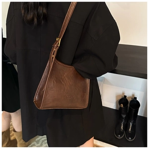 Detail of vintage brown leather tote bag showing fine texture and embossed fashion text