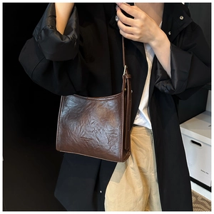 Detail view of deep brown vintage tote bag with wrinkled leather texture and logo