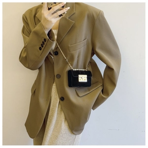 Close-up of black velvet mini crossbody bag with gold chain strap and heart clasp