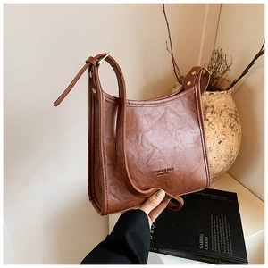 Detailed shot of brown faux leather tote with vintage texture and adjustable strap