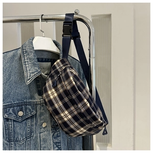 Détail du sac de poitrine à carreaux avec bandoulière en nylon et boucle sur veste