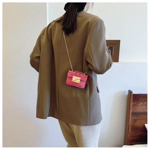 Detail of rose red suede mini bag with gold chain strap and metallic square buckle