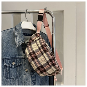 Détail du sac banane à carreaux roses avec sangle réglable et boucle sur un cintre