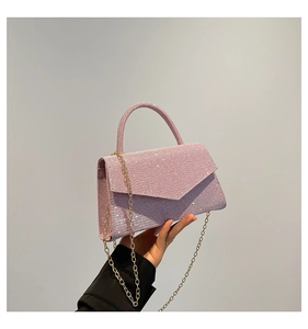 Detailed view of pink glitter evening bag with metallic chain strap and envelope flap