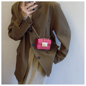Detailed macro view of the fuchsia suede mini crossbody bag with silver metal chain
