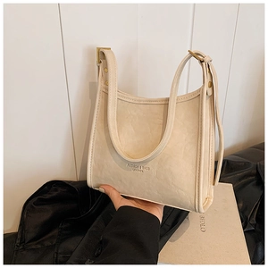 Detail of beige faux leather tote with U-shaped design and elegant side metal buckle