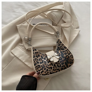 Detail of leopard print crescent bag with silver bow buckle and cream leather trim
