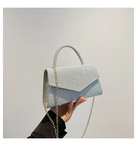Detail of silver glitter evening bag with V-shaped flap and golden metal chain strap
