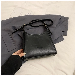 Close-up of black leather tote bag featuring Fashion & Bags embossed lettering and texture
