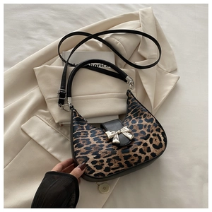 Macro shot of leopard print fabric texture and silver bow buckle on crescent bag
