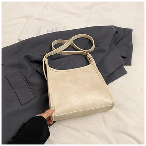 Detailed view of cream-colored retro tote bag with adjustable strap and metal hardware