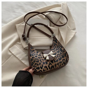 Detail of leopard print hobo bag with silver bow ornament and dark brown leather strap