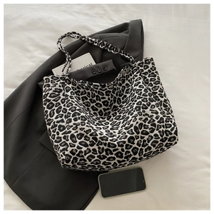 Flat lay showing detailed leopard print texture on a large canvas tote bag for women
