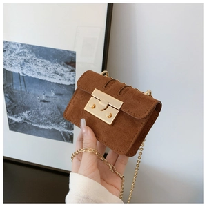 Detail of brown faux suede mini bag with gold chain and large metal buckle
