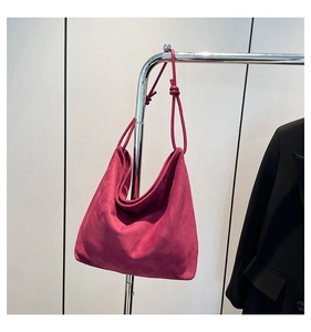 Detail of magenta faux suede hobo tote bag featuring minimalist knot strap design