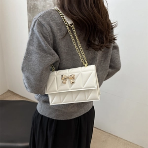 Sac bandoulière matelassé blanc avec fermoir papillon doré et bandoulière chaîne