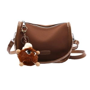 Retro matte saddle bag in dark brown with plush monster charm and adjustable strap