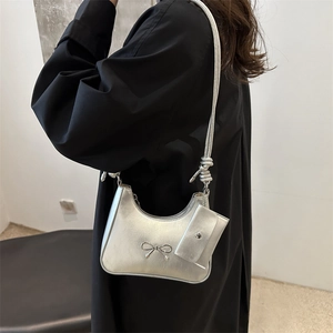 Silver hobo shoulder bag with metal bow accent and matching mini pouch for women