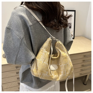 Detail of yellow knit hobo bag with a white fashion leather patch and slim shoulder strap