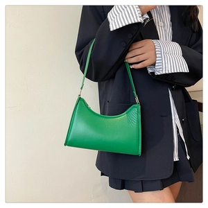 Detail of emerald green moon-shaped armpit bag in synthetic leather with gold zipper