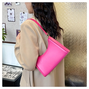 Vibrant pink leather underarm bag styled with a beige suit for a trendy casual look