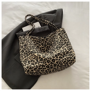 Close-up of leopard print canvas tote bag on black blazer for fashion styling